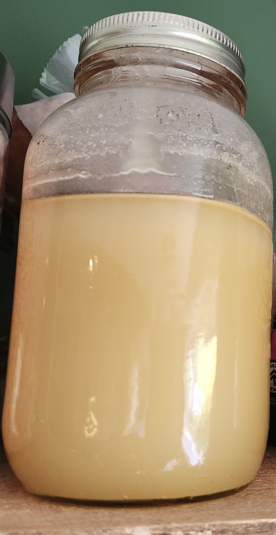 A jar of crystallized raw honey, thick and opaque.