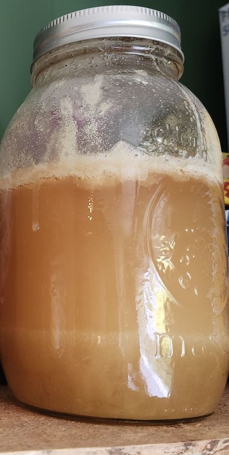 A jar of fermented honey, showing separation and a bubbly appearance.